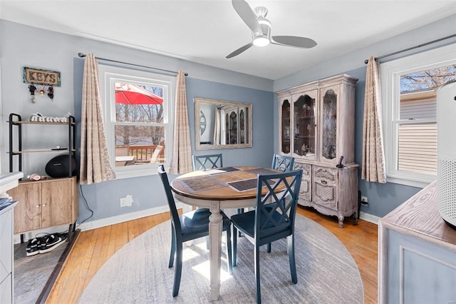 dining area with light wood-style flooring, baseboards, and ceiling fan