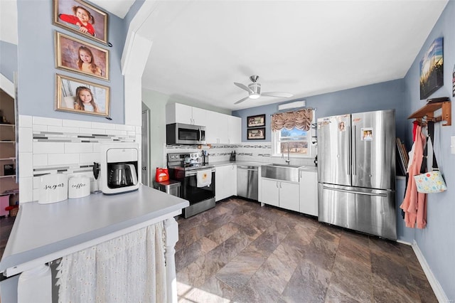 kitchen with stainless steel appliances, tasteful backsplash, light countertops, and white cabinets