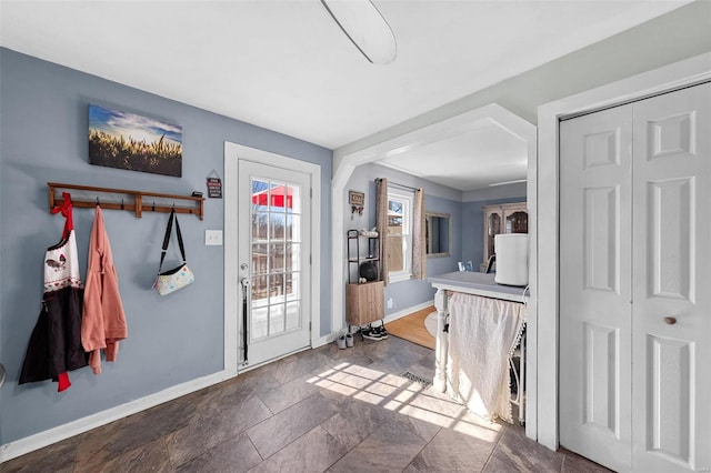 entryway featuring stone finish flooring and baseboards