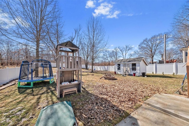 view of yard featuring a fenced backyard, a trampoline, and an outdoor structure