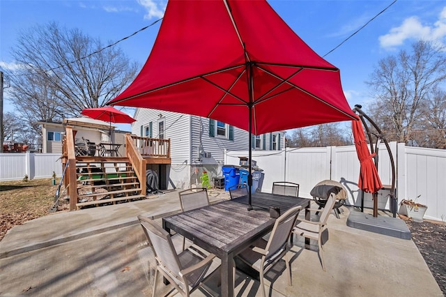 view of patio with a wooden deck, stairway, a fenced backyard, and outdoor dining space