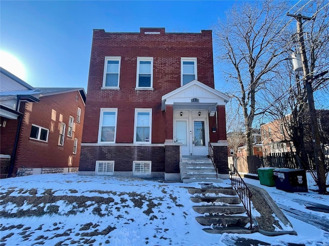 view of front facade with brick siding and fence