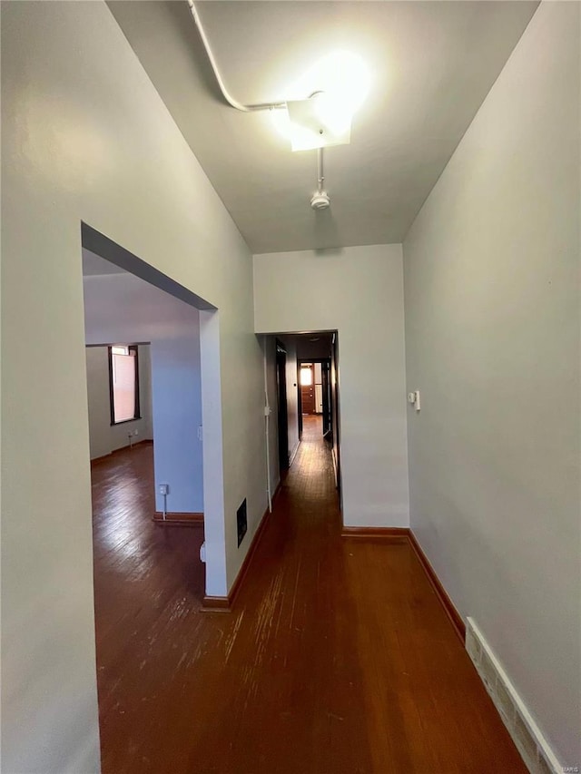 hallway with wood-type flooring and baseboards