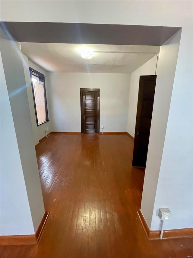 unfurnished room featuring hardwood / wood-style floors and baseboards