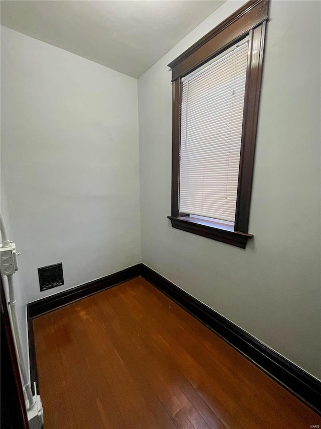 unfurnished room featuring dark wood-type flooring and baseboards