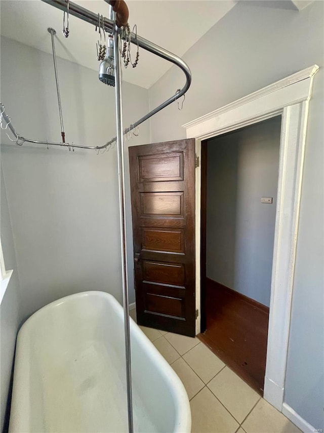 bathroom featuring a freestanding tub and tile patterned flooring