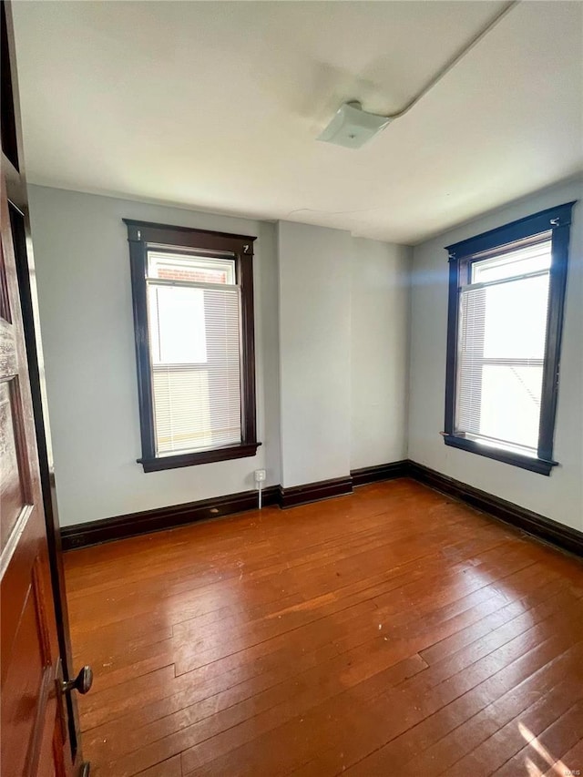 empty room with hardwood / wood-style flooring and baseboards