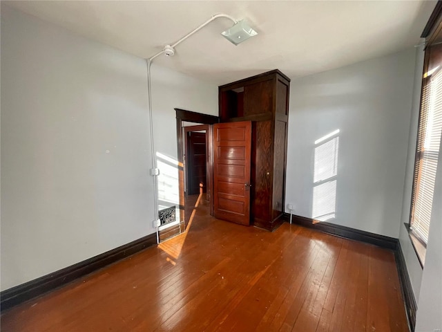 empty room featuring hardwood / wood-style flooring and baseboards