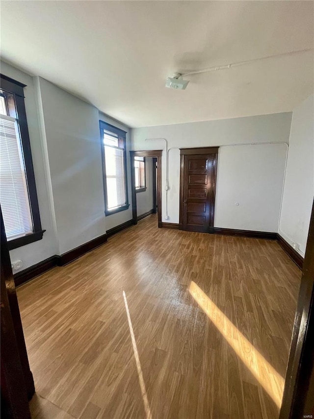 unfurnished bedroom featuring wood finished floors and baseboards