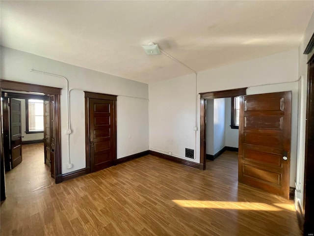 unfurnished room with baseboards and wood finished floors