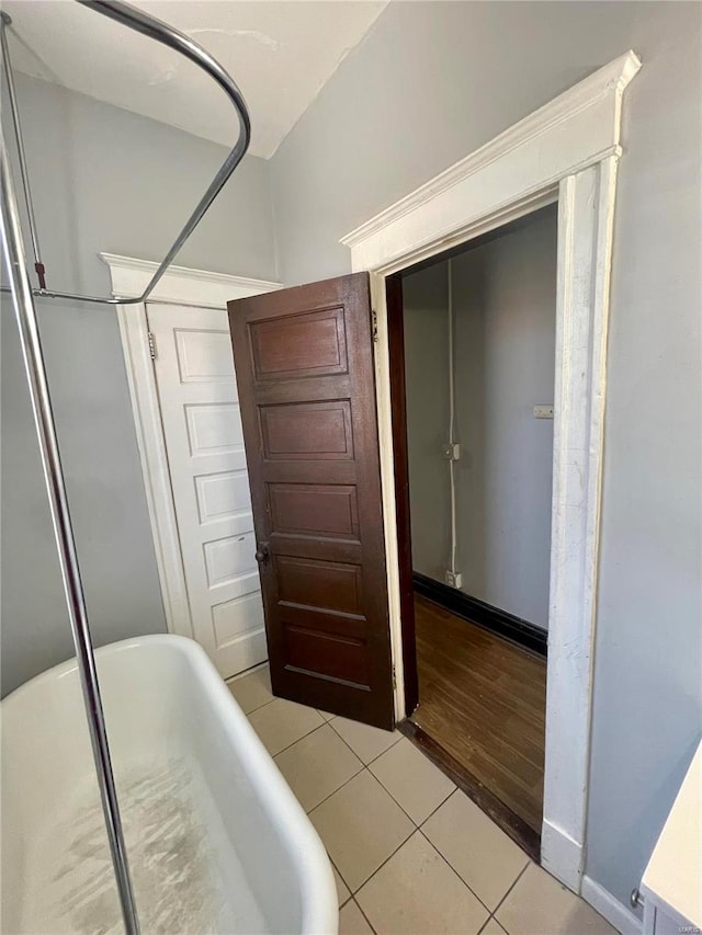 bedroom featuring light tile patterned floors, a closet, and baseboards