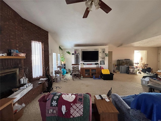 living room featuring a ceiling fan, carpet, a brick fireplace, and lofted ceiling