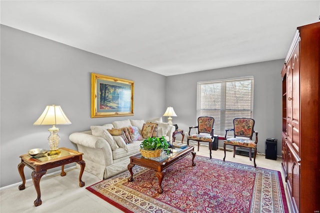 living area featuring light carpet and baseboards