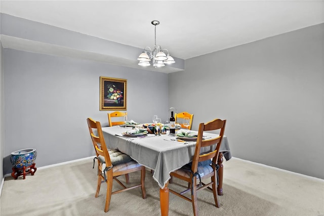 dining area featuring light carpet, a notable chandelier, and baseboards