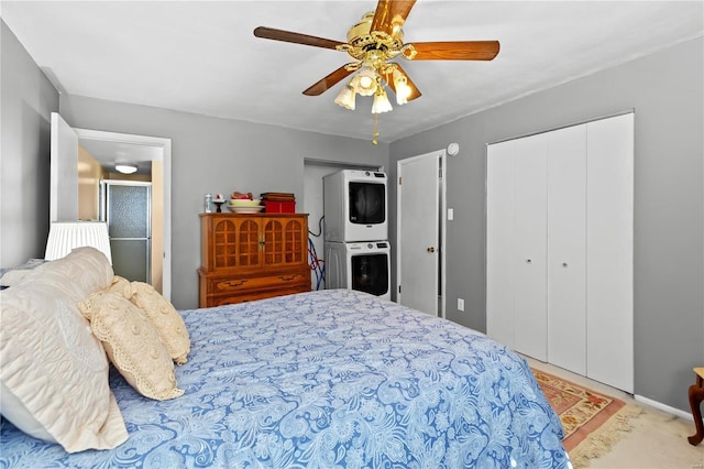 bedroom featuring a closet, a ceiling fan, and stacked washer / dryer