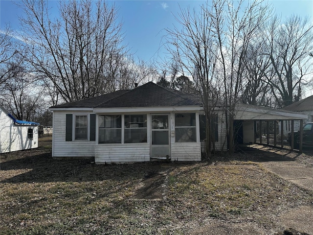 view of front facade with concrete driveway, a carport, and a sunroom