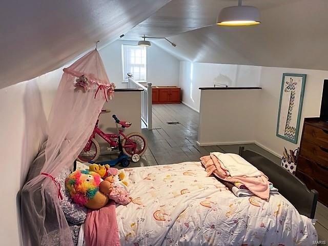 bedroom with lofted ceiling and wood-type flooring