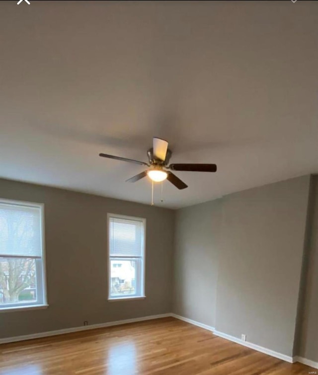 spare room with a healthy amount of sunlight, light wood-style floors, and baseboards