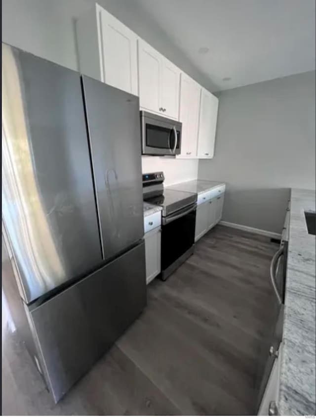 kitchen with dark wood-style floors, stainless steel appliances, white cabinetry, and baseboards