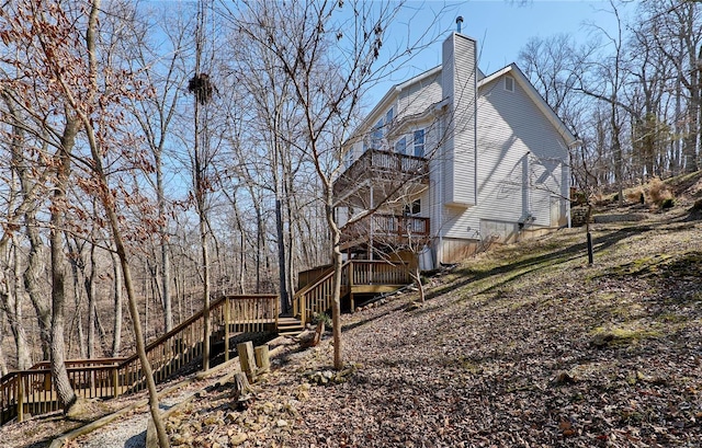 view of home's exterior with a chimney and a wooden deck