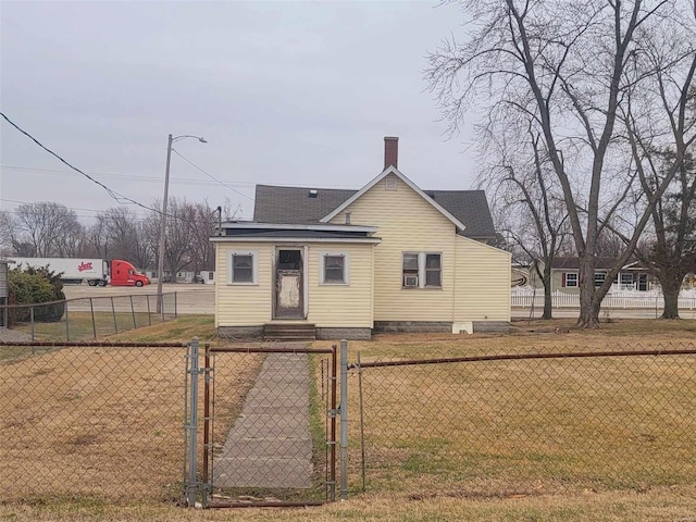 bungalow with a chimney, a gate, fence, and a front lawn