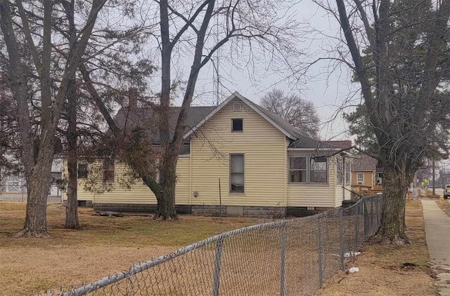 view of property exterior with a fenced front yard and a shingled roof