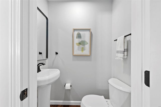 bathroom with baseboards and toilet