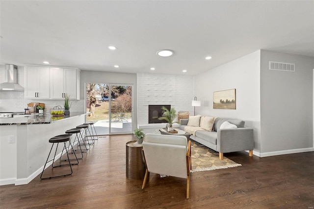 living room featuring a fireplace, recessed lighting, visible vents, dark wood-type flooring, and baseboards