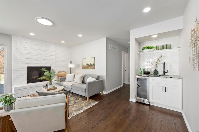 living area with beverage cooler, visible vents, dark wood-style floors, a fireplace, and recessed lighting