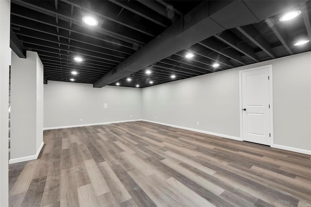 finished below grade area featuring baseboards, wood finished floors, and recessed lighting