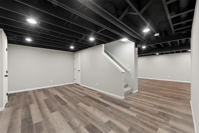 finished basement with stairway, wood finished floors, and baseboards