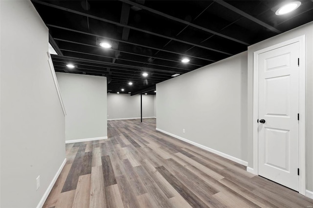 finished basement featuring baseboards and wood finished floors