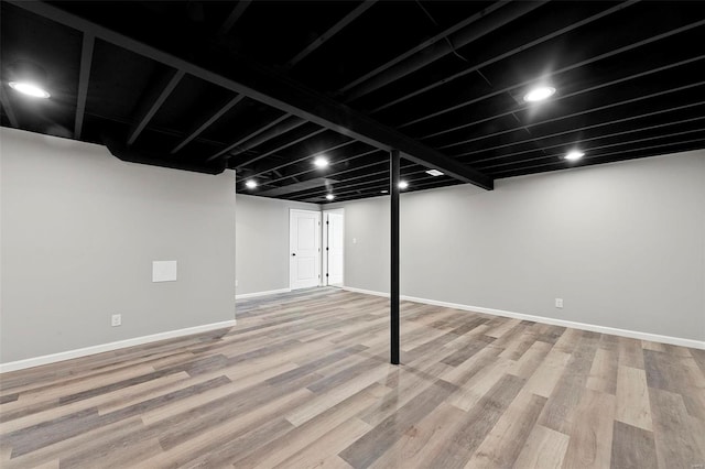 finished below grade area featuring wood finished floors and baseboards