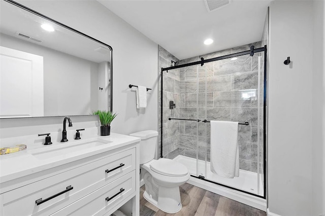 bathroom with visible vents, a shower stall, and wood finished floors