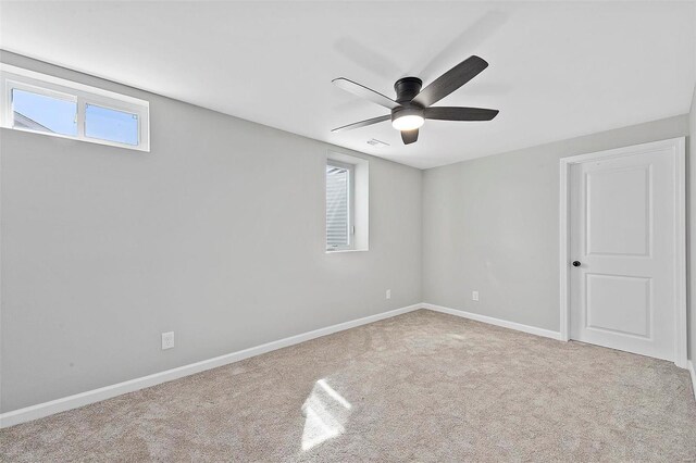 empty room with carpet, visible vents, baseboards, and a ceiling fan