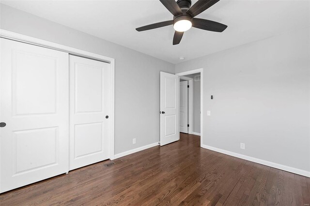 unfurnished bedroom featuring ceiling fan, a closet, wood finished floors, and baseboards