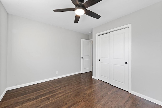 unfurnished bedroom with ceiling fan, dark wood-style flooring, a closet, and baseboards