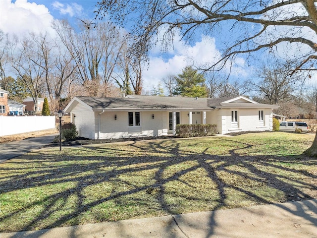 ranch-style house featuring a front yard, fence, and brick siding