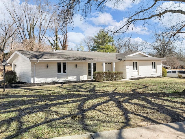 ranch-style house featuring brick siding and a front lawn