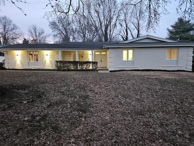 rear view of property with brick siding and a chimney