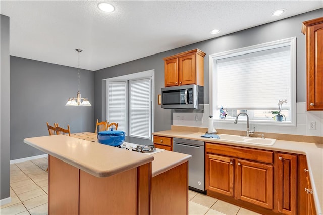 kitchen featuring light tile patterned floors, light countertops, appliances with stainless steel finishes, and a sink