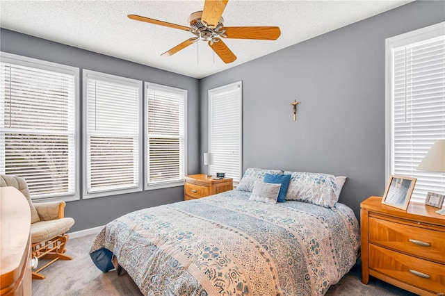 bedroom featuring ceiling fan, a textured ceiling, baseboards, and carpet flooring