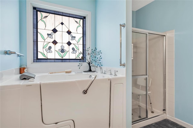 bathroom with a stall shower and a garden tub