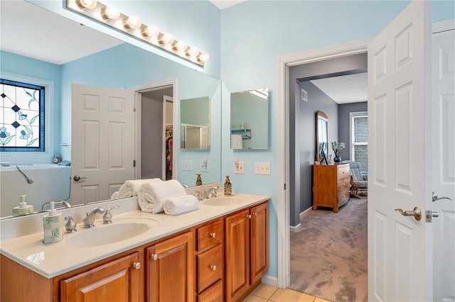 full bathroom with tile patterned floors, a sink, a textured ceiling, and double vanity