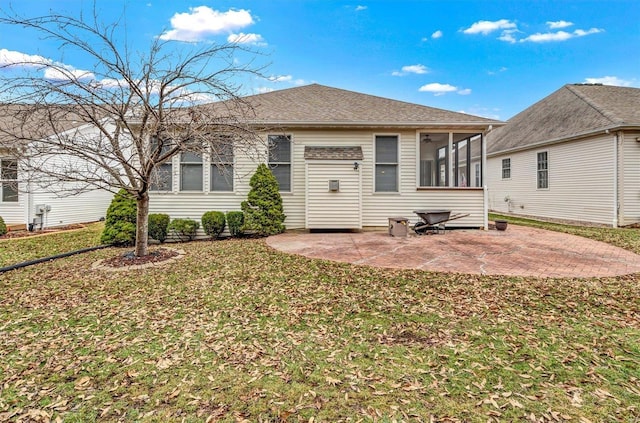 rear view of property with a yard, a sunroom, a patio, and a shingled roof