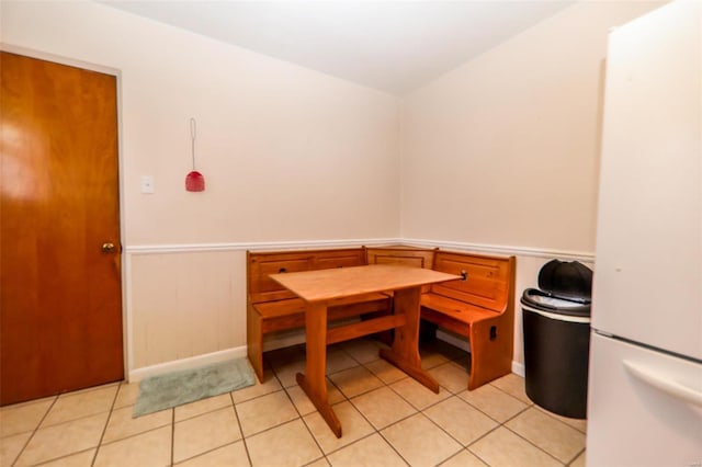 dining area featuring breakfast area, wainscoting, and light tile patterned floors