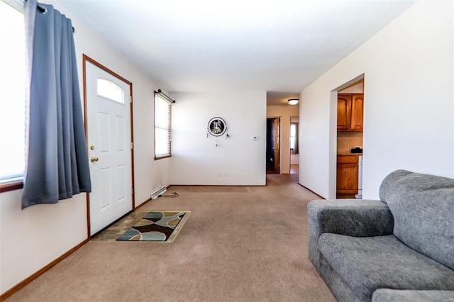 living room with baseboards, a baseboard heating unit, and light colored carpet