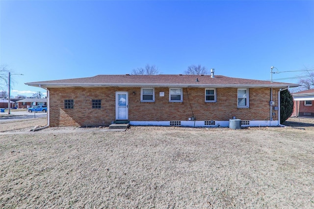 back of property with entry steps, brick siding, and central AC unit