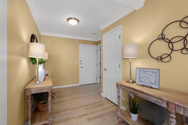 hall featuring visible vents, baseboards, crown molding, and light wood-style floors