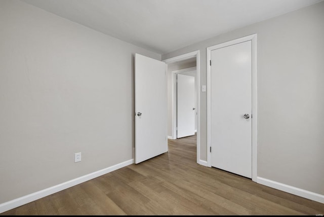 unfurnished bedroom with baseboards and wood finished floors